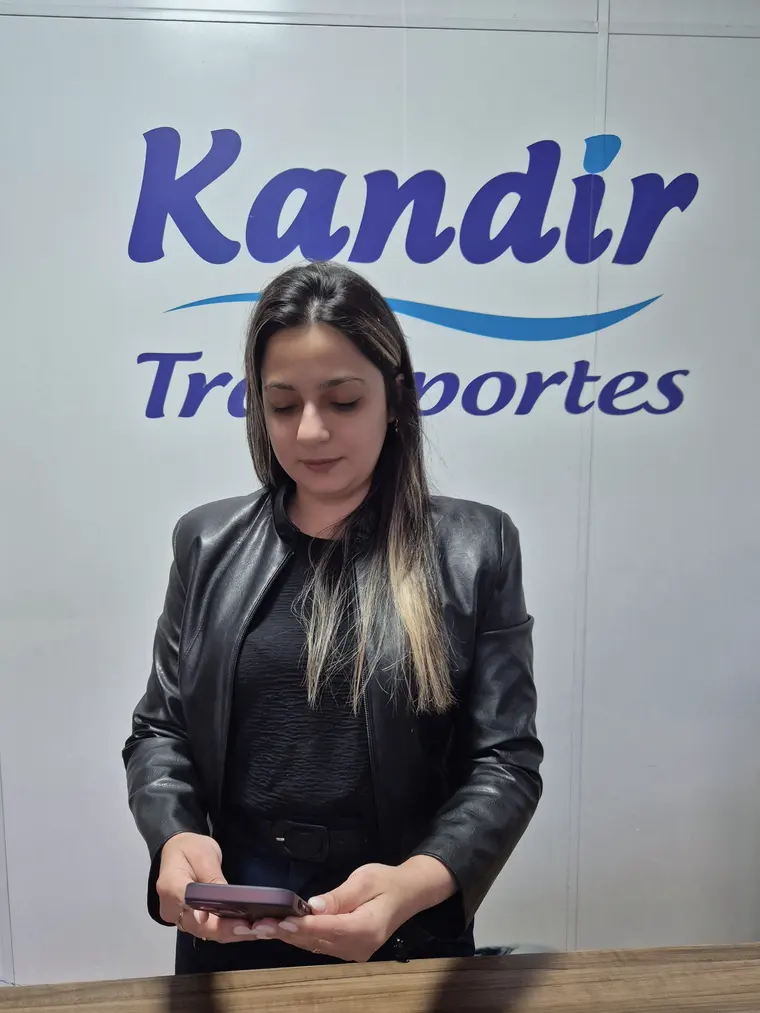 No escritório da Kandir Transportes, uma coordenadora acompanha os serviços pelo celular.